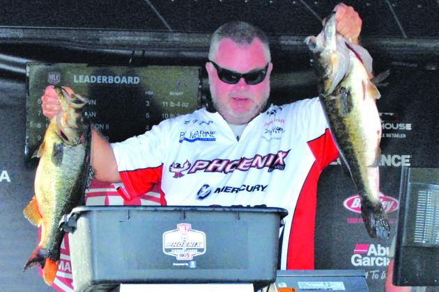 First-place boater David Lowery holds up two of his winning fish Friday. (GREG WALKER / Daily News correspondent)