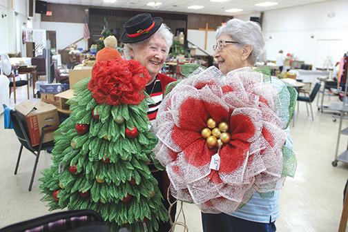 St. James United Methodist Church members Carolyn Flanders, left, and Ruth Vickers show some of the unique wall or door hangings that will be available for purchase at the church’s annual bazaar. 
