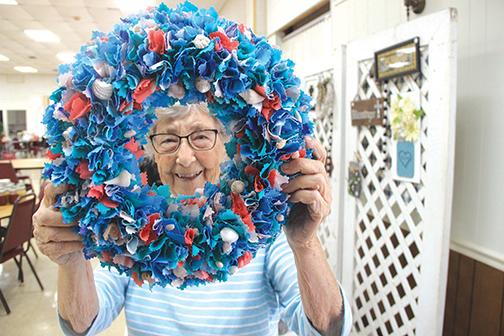 Vickers has a smile on her face looking at one of the donated wreaths the bazaar will feature Friday and Saturday at the church.