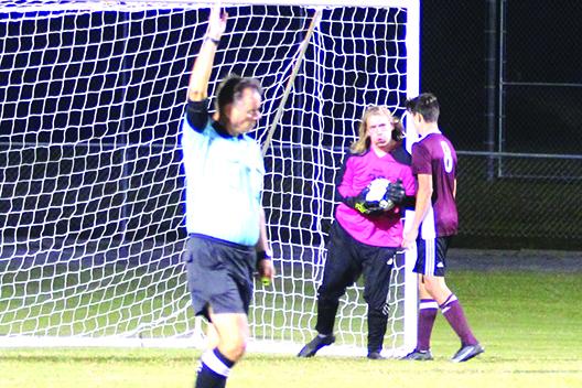 Crescent City's David Newbold (8) shelters teammate and goalkeeper Jack Lewandowski after stopping Tyler Colaw’s first-half penalty kick. (MARK BLUMENTHAL / Palatka Daily News)