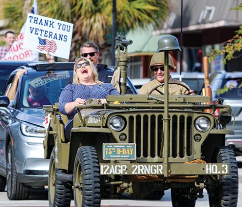 U.S. Rep. Kat Cammack, R-Fla., laughs with residents standing along St. Johns Avenue on Thursday as she rides in the Palatka Veterans Day Parade.