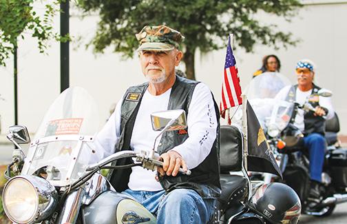 A veteran glides down St. Johns Avenue with an American flag waving on the back of his motorcycle Thursday.