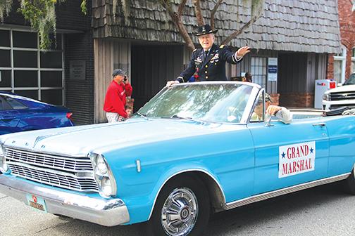 Grand Marshal George S. Crawford waves to the crowd who lined St. Johns Avenue in Palatka on Thursday for the annual Veterans Day parade.