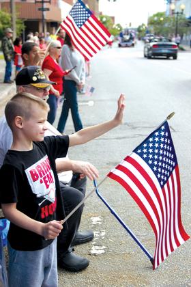 Wyatt Norris, 6, waves to the Veterans Day parade participants Thursday on St. Johns Avenue.