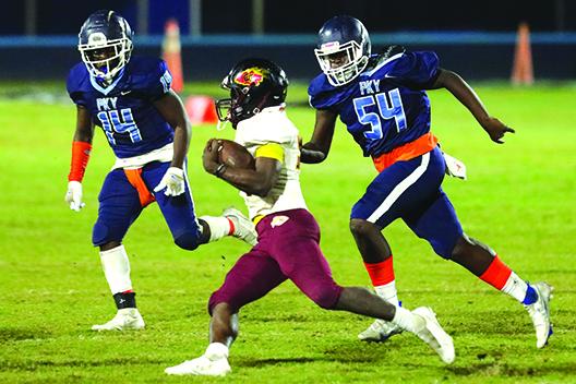 Crescent City running back Dazail Dennis tries to outrun P.K. Yonge defenders Ernest Davis (14) and Kyler Ingram during Friday night’s FHSAA Region 1-3A first-round matchup in Gainesville. (BRAD McCLENNY / Special to the Daily News)