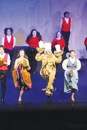 Timothy Lake (center, as Lumiere) and Megan Lingle (right, as Belle) and ensemble cast members perform “Be Our Guest” from Disney’s Beauty and the Beast as part of the revue show, “All Together Now!”