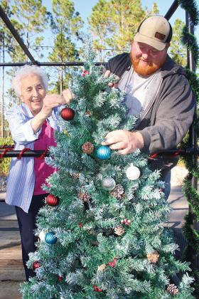East Palatka residents Rosa Scileppi and her grandson, Mike Scileppi, make adjustments to the Christmas tree that will be on the family’s float in the City of Palatka Christmas Parade.