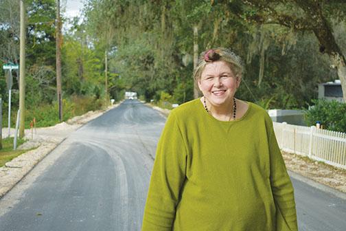 Sandra Lee Harvey stands on Bainbridge Road in front of her Palatka home. The road was paved in October, and nearby roads are slated to be paved starting next month.