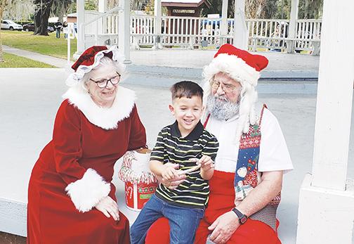 A child sits in Santa Claus’ lap as he tells Santa and Mrs. Claus what he wants for Christmas during Crescent City’s 2019 holiday celebration.