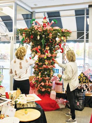Tiffany Parker Flanders, left, and Kathy Griffin put the finishing touches on a holiday tree display at Lady Bug’s Gift Shoppe in downtown Palatka during Small Business Saturay.