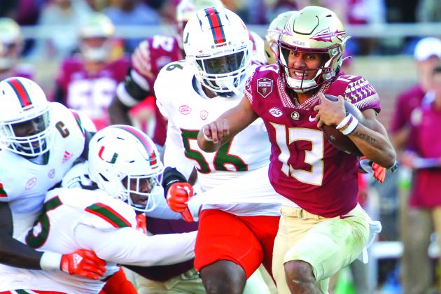 Florida State’s Jordan Travis (13) escapes away from Miami’s Leonard Taylor during the Seminoles’ victory over the Hurricanes on Nov. 13. (GREG OYSTER/Palatka Daily News)