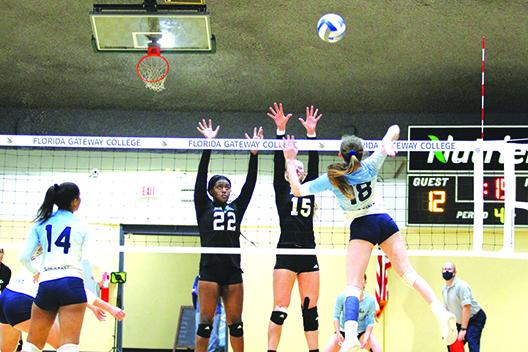 St. Johns River State College’s Rickie Sheets (18) looks for a kill attempt as Lake-Sumter’s Taylor Lawrence (22) and Emma Rome attempt to block during the third set of Saturday’s Gulf District JUCO Division II final at Florida Gateway College. (MARK BLUMENTHAL / Palatka Daily News)
