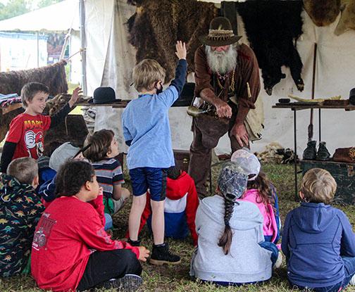 A living history actor portraying trader Job Wiggens shows Putnam County students how to make a fire during the Bartram Frolic at the Palatka riverfront. 