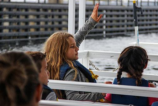 Kelley Smith Elementary School student Mia Linares raises her hand to answer a question Thursday while on a boat tour along the St. Johns River.