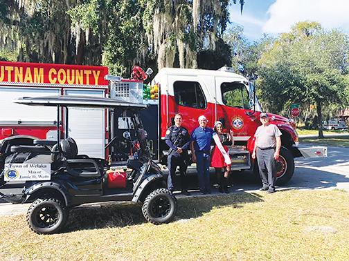 Mayor Jamie Watts stands with the Welaka Volunteer Fire Department on Saturday after participating in the Crescent City Christmas Parade.