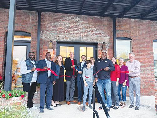 Palatka city officials and building owner Charlie Douglas, fifth from left, celebrate Douglas Law Firm’s new location on Second Street with a ribbon-cutting this week. 