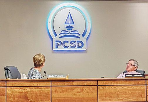 Putnam County School District board members Holly Pickens and David Buckles regard the mounted, lit version of the district’s new logo in the board’s meeting room during a meeting Tuesday afternoon.