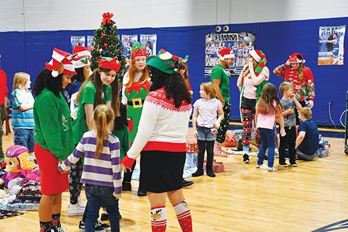 Elves Adeonna Rivera, Abby Hilliard, Payton Alexander, Nate Bernardini, Allyson Greenan and Dixie Smith spread some holiday cheer to elementary school children Thursday. 