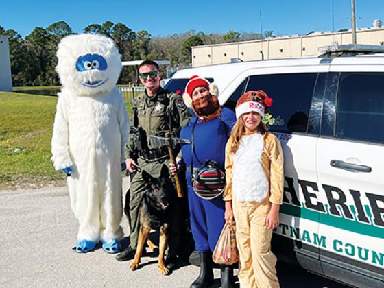 Putnam County Sheriff’s Office Deputy Kagen Butts and K-9 deputy Halo stand with K9s United members – BJ Johnson as the Abominable Snowman, Debbie Johnson as Yukon Cornelius and 10-year-old Emma Johnson as Rudolph – before receiving a gift on Christmas Eve, courtesy of K9s United.