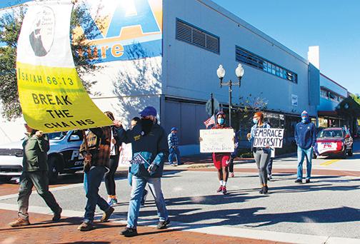 People march in Palatka’s Martin Luther King Jr. Parade on Monday carrying promoting unity and discouraging.