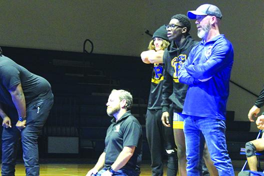 Kneeling Palatka head coach Josh White watches a match while (from left) wrestlers Alex McCrystal and Johnson Session and assistant coach Richie Lewis give encouragement. (MARK BLUMENTHAL / Palatka Daily News)