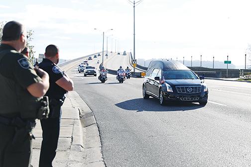 Deputies watch as a processional for a fallen Hillsborough County deputy travels over Memorial Bridge and into Palatka on Wednesday.