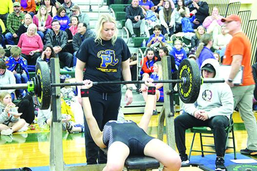 Palatka Junior-Senior High School girls weightlifting coach Katelynn Smith spots one of her lfiters at Saturday’s Region 2-1A championship. (COREY DAVIS / Palatka Daily News)