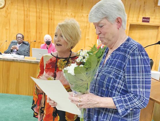 Also during the meeting, Crescent City Mayor Michele Myers, left, presents Cherie Register on Thursday night with a proclamation naming her honorary city historian. Commissioners Harry Banks and Cynthia Burton listen in the background.