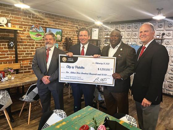 From left, Palatka City Manager Don Holmes, Gov. Ron DeSantis, Palatka Mayor Terrill Hill and Rep. Bobby Payne pose for a photo in Madison, Fla., with a ceremonial check from the state for infrastructure funds.
