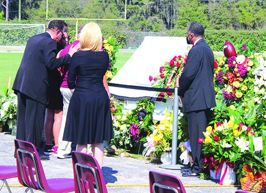 Karl Flagg embraces Jordan Williams and Wes Thompson in front of the open casket of Clarence "Pooh Bear" Williams before Saturday's service. (MARK BLUMENTHAL / Palatka Daily News)