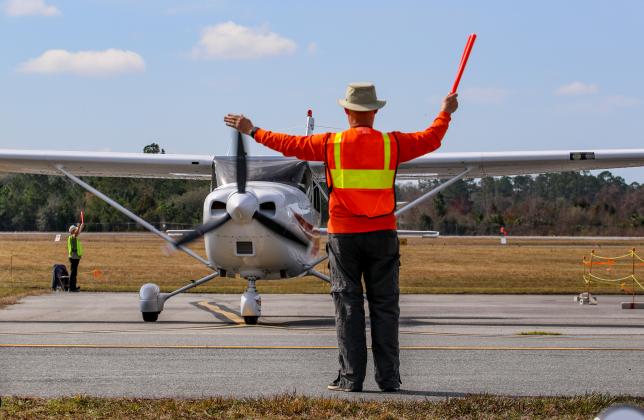 A man directs a plane taking off at the Palatka Municipal Airport on Saturday. 