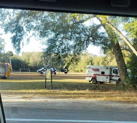 An Emergency Medical Services truck and helicopter assist patients near the crash site.