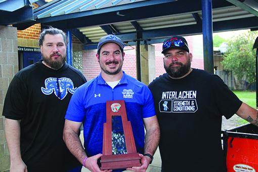 Interlachen assistants (from left) Jonathan Goodwin and Jordan Smalenski and head coach Tad DeLoach show the second-place team trophy the Rams captured on Wednesday. (COREY DAVIS / Palatka Daily News)