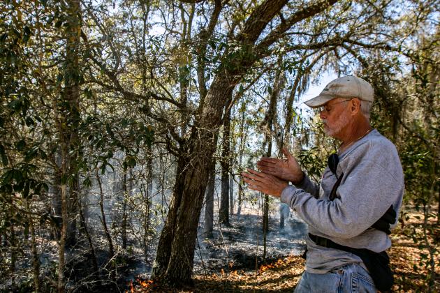 Photo by Sarah Cavacini/Palatka Daily News. Ben Williams describes the prescribed burn process Sunday as the Wetland Preserve grounds burn behind him.