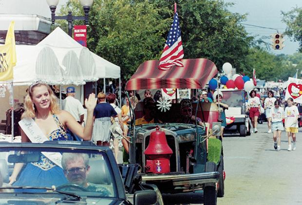 A pageant queen waves to the crowd while participating in the Memorial Day parade during the Blue Crab Festival in 1996.