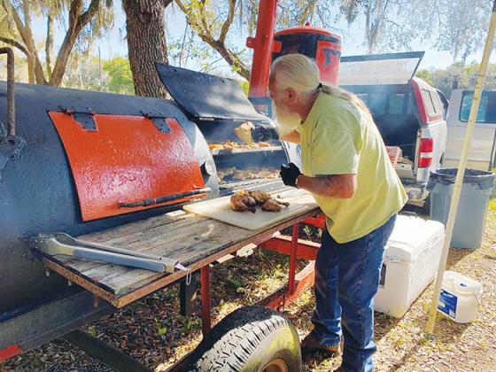 Florahome resident Richard Probeck Sr. cooks barbecue Saturday after the cycle ride.
