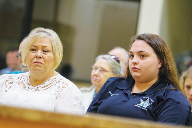 Putnam County Sheriff’s Office Cpl. Klarissa Fleming, right, sits next to a family member Tuesday while she listens to the call from March 2 when she helped a woman in a domestic violence situation.