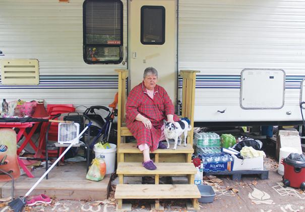 Judie Holman sits with her dog in front of her RV at St. Johns Campground in East Palatka on Thursday.