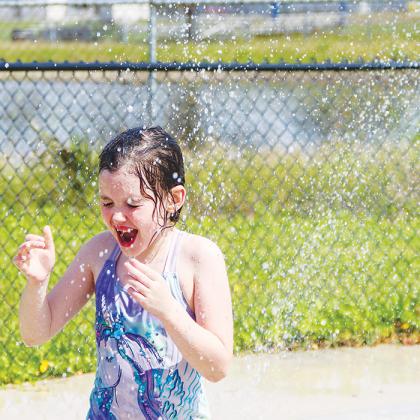 Delia Keller laughs in the splash pad at the John Theobold Sports Complex’s Project P.L.A.Y. on Monday.