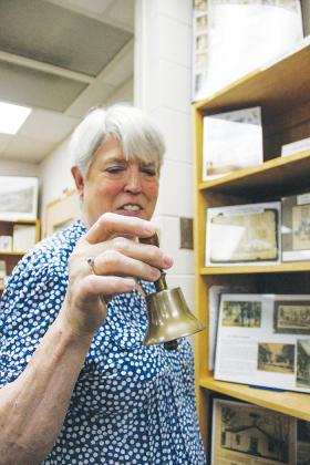 Fruitland Peninsula Historical Society member Cherie Register looks over old photos from Crescent City on Wednesday at the society’s Margary Neal Jones Nelson Archives.