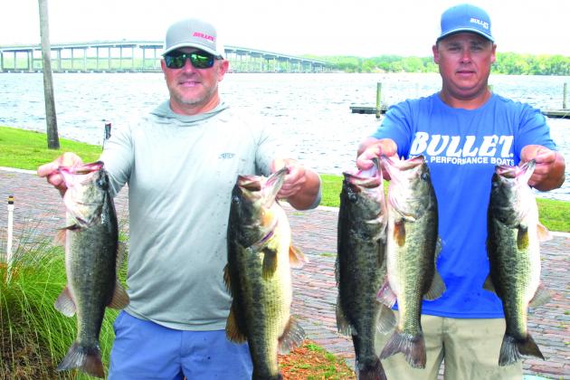 Jason Caldwell, left, and Lee Stalvey hold up their winning fish in the  Messer’s Invitational Bass Tournament held recently. (GREG WALKER / Daily News correspondent)