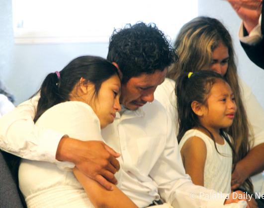 Jose Lara Sr. comforts his wife, Maria, during their son’s viewing at Jesus Christ is Lord Church in Crescent City while Jose’s sister, Jocelyn, 6, is comforted by a family member. (TRISHA MURPHY/Palatka Daily News)