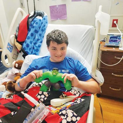 Kaleb Sheneman, whose leg was broken after being hit by a car last week, smiles with a Hulk toy as he continues to recover at UF Health in Gainesville.