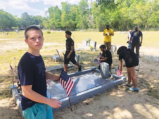 Interlachen Junior-Senior High School JROTC cadets clean the grave of Pfc. Robert H. Jenkins Jr. on Saturday.