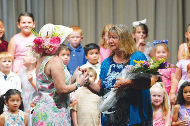Heather Kirby hands Janet Greene flowers on behalf of the first grade teachers at Jenkins Elementary. Greene is the last of the original teachers who helped institute the Mother’s Day program at the school in 1999.