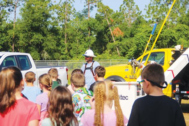 Ochwilla Elementary School students watch a demonstration by a Clay Electric Cooperative employee Tuesday during the school’s career day.
