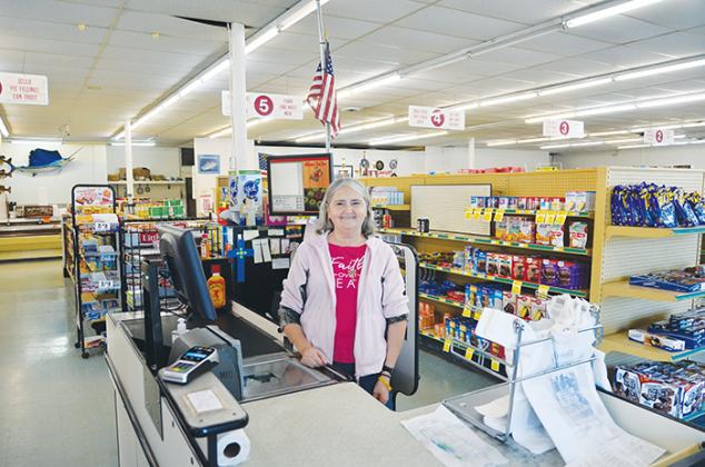 Cashier Denise Mason stands beside her cash register at Williamson's Food Store Wednesday.