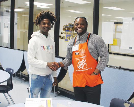 Home Depot Manager Pankell Elliot shakes hands with Palatka Junior-Senior High School student Tivon Adams during a round of mock interviews Friday.