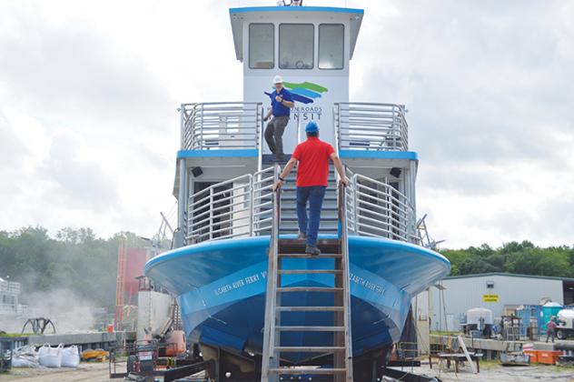 Mike Perez, foreground, operation projects and contracts administrator for Hampton Roads Transit, climbs aboard the Elizabeth River Ferry VI, which his company contracted with St. Johns Ship Building to complete. 