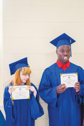 Holly Donahoe, left, and Willie Williams Jr. hold their diplomas after their graduation service, the third of a series of commencement ceremonies to occur throughout Putnam County this week.